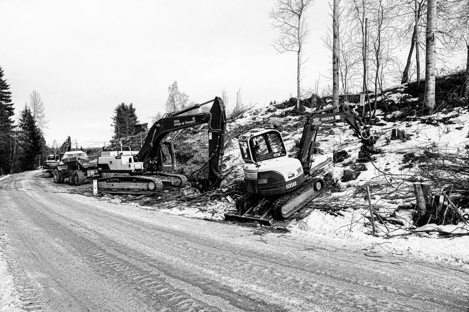 To gravemaskiner ved en norsk VA-grøft langs vintervei.